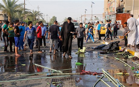 People gather at the site of a suicide-bomb attack in Baghdad’s Shi’ite slum of Sadr city today