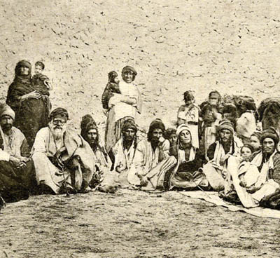 Post-Card by Sarrafian brothers of Beirut of a group of Yezidis of Jabal [mountain] of Sinjar at the Iraqi-Syrian border. The Yezidi Kurds started settling in the mountain beginning in the 13th. century following the severe persecution by the Zengid Atabeg of Mosul, Badr al-Din Lulu. and later by the frequent Ottoman campaigns against the Sheikhan Yezidis north of Mosul. The mountain was a strong hold of the Nestorian Christians, who's Diocese ceased to exist after the 17th. century. The first of many campaigns by the Ottoman Turks, against the Yezidis of the Mountain, called by the Turks "THE SACLI DAGH", the mountain of the "HAIRY ONE'S", was carried by Melek Ahmad Pasha, the Vali of Diyarbekir [ 1640], the second by the Ottoman Firari Mustapha, the last occupation was in 1918, and directed against Hamu Sharu, the Sheikh of the Fuqara Yezidis, who refused to hand in the Christians refugees who sought shelter in the mountain from S.E.Turkey.