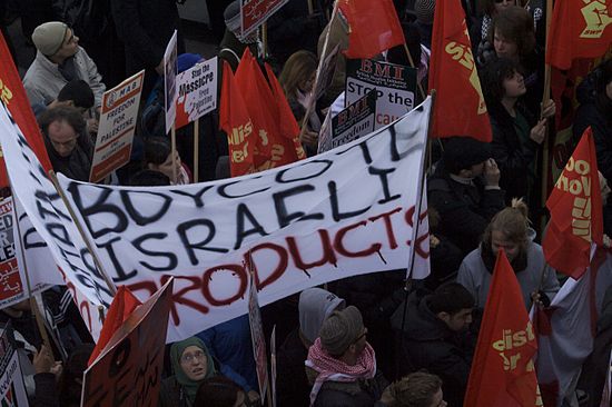 BDS supporters protesting in London. The poster reads, "Boycott Israeli Products".